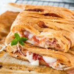 Una ricetta veloce e deliziosa per preparare uno strudel di pasta sfoglia con prosciutto e formaggio, perfetto per qualsiasi spuntino o piccolo pasto!